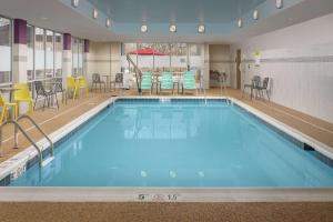 a large swimming pool with chairs and a table at Home2 Suites By Hilton Edison in Edison