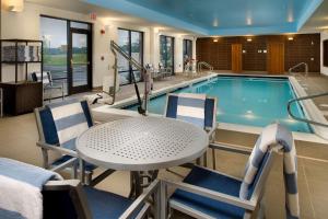 a swimming pool with a table and chairs and a table and a tablektopktop at Hampton Inn and Suites Washington DC North/Gaithersburg in Gaithersburg