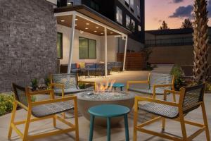 Home2 Suites by Hilton San Antonio Lackland SeaWorld في سان انطونيو: فناء مع كراسي ومدفأة