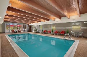 a pool in a hotel with red chairs and tables at Home2 Suites by Hilton Baltimore/White Marsh in White Marsh