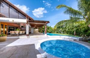 a backyard with a swimming pool and a house at Sunny vacation Villa No 76 in San Rafael del Yuma