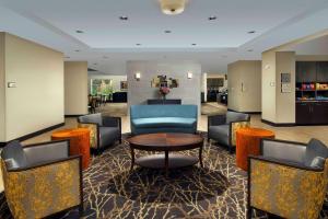 Homewood Suites San Antonio Airport في سان انطونيو: لوبي فيه كراسي وطاولة في الفندق