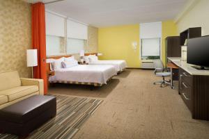 a hotel room with two beds and a flat screen tv at Home2 Suites by Hilton Arundel Mills BWI Airport in Hanover