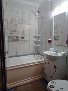 een badkamer met een bad, een wastafel en een douche bij Modern Beach Apartment in Constanţa