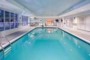 a large swimming pool with blue water in a building at Hampton Inn Ithaca in Ithaca