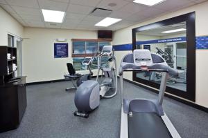 un gimnasio con máquinas de correr y espejo en Hampton Inn Ithaca, en Ithaca