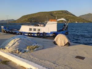 a boat is parked next to the water at Evriaki Rooms Lesvos in Apidias Lakos