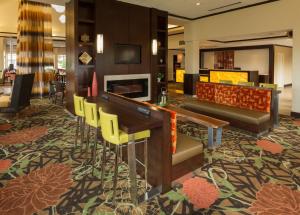 a hotel lobby with a desk and chairs at Hilton Garden Inn Buffalo Airport in Cheektowaga