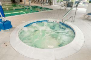 a jacuzzi tub in a building with a pool at Hilton Garden Inn Buffalo Airport in Cheektowaga