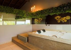 a large bathroom with a tub with grapes on the wall at Amora Hotel Maresias in Maresias