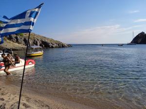 Bandera en una playa con barcos en el agua en Maria, en Apidias Lakos