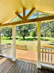 um grande alpendre de madeira com um banco num deque em Small Home near Lake Fork with Stocked Pond em Emory