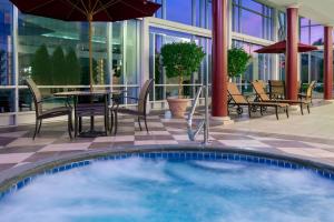 una piscina en un patio con mesa y sillas en Hampton Inn & Suites Buffalo/Downtown en Buffalo