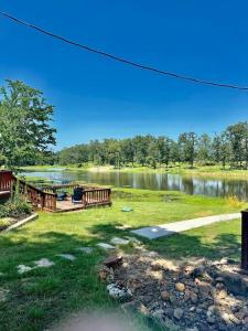 uma vista para um lago com uma casa e uma doca em Small Home near Lake Fork with Stocked Pond em Emory