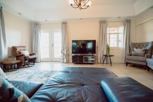 a living room with a couch and a flat screen tv at Executive Three Bedroom Condo on the Greens in Trincity 