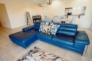 a blue leather couch in a living room at Executive Three Bedroom Condo on the Greens in Trincity 