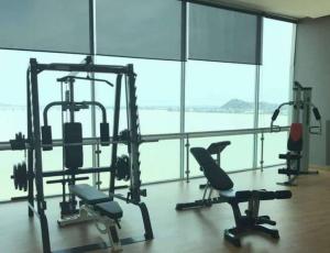 un gimnasio con equipo cardiovascular en una gran sala con ventanas en Hermoso departamento 2 cuartos vista al rio. en Guayaquil