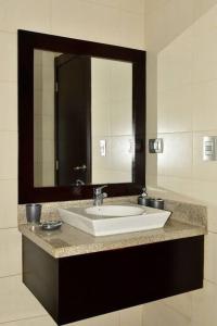 baño con lavabo y espejo grande en Hermoso departamento 2 cuartos vista al rio. en Guayaquil