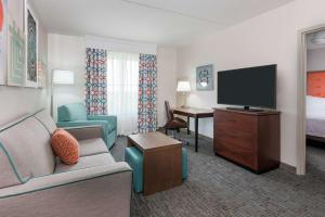 a hotel room with a couch and a flat screen tv at Homewood Suites by Hilton Cleveland-Beachwood in Beachwood