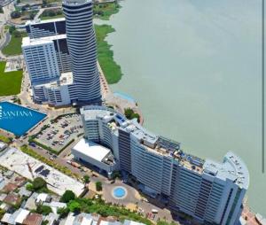 una vista aérea de una ciudad con un edificio alto en Hermoso departamento 2 cuartos vista al rio. en Guayaquil