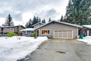 a house with a garage in the snow at Juneau Apartment - Minutes to Mendenhall Glacier in Juneau