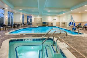 a pool in a hotel with tables and chairs at Hilton Garden Inn Wayne in Wayne