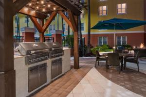 an outdoor patio with a grill and a table with chairs at Homewood Suites by Hilton Orlando-UCF Area in Orlando