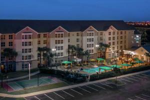 a large building with a tennis court in front of it at Homewood Suites by Hilton Orlando-Nearest to Universal Studios in Orlando
