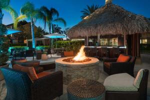 uma fogueira num resort com cadeiras e mesas em Hilton Garden Inn Orlando International Drive North em Orlando