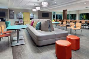 奥兰多Home2 Suites By Hilton Orlando Near Universal的带沙发和桌椅的客厅