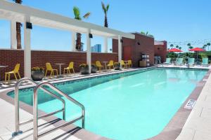 une grande piscine avec des chaises et des tables jaunes dans l'établissement Home2 Suites By Hilton Orlando Near Universal, à Orlando