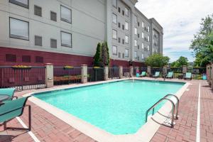 a swimming pool with chairs and a building at Hampton Inn South Plainfield-Piscataway in South Plainfield