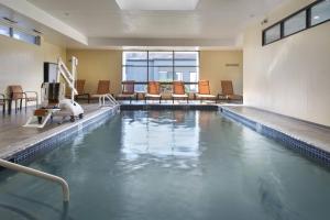 an indoor swimming pool with chairs in a building at Courtyard by Marriott Norwalk in Norwalk