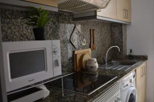 a kitchen with a microwave and a sink at Acogedor piso cerca de la playa in Puerto de Sagunto