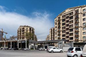 a parking lot with cars parked in front of buildings at Istanbul Apartment 01 in Tashkent