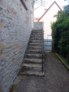 un conjunto de escaleras que conducen a una pared de ladrillo en Maison Thalène, en Longraye