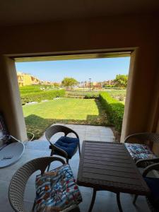a patio with a table and chairs and a view of a yard at Mountain View 1 /Ain El Sokhna in Ain Sokhna