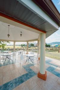 a patio with tables and chairs on a roof at Executive Three Bedroom Condo on the Greens in Trincity 