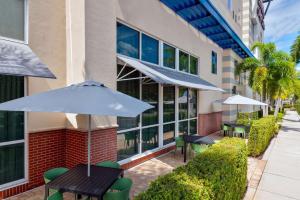 a patio with tables and umbrellas in front of a building at Hampton Inn and Suites Sarasota/Lakewood Ranch in Sarasota