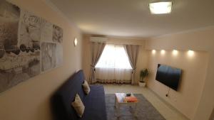 a living room with a blue couch and a television at PORTUGAL HOLIDAYS in Luz
