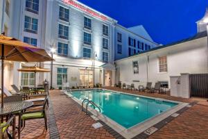 a swimming pool with tables and chairs next to a building at Hilton Garden Inn Nashville Brentwood in Brentwood