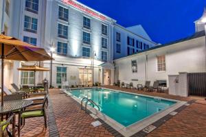 ブレントウッドにあるHilton Garden Inn Nashville Brentwoodの建物の隣にスイミングプール(テーブル、椅子付)