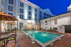 una piscina con tavoli e sedie accanto a un edificio di Hilton Garden Inn Nashville Brentwood a Brentwood