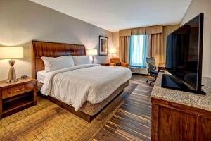 a hotel room with a bed and a flat screen tv at Hilton Garden Inn Nashville Brentwood in Brentwood