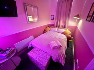 a pink bedroom with a bed and a desk at Blackpool Rocks Pleasure Beach in Blackpool
