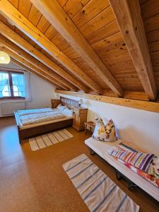 a attic room with two beds and two rugs at Ferienhaus: idyllisch & erholsam in Eglofs
