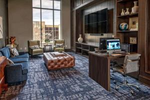 a living room with a computer and a desk with a television at Hilton Nashville Green Hills in Nashville