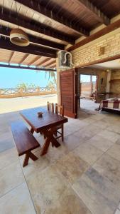 a wooden table and chairs on a patio at BEACH HOUSE - Loggia Suite 4 - com cozinha - na praia -BEACHFRONT in Barra Grande
