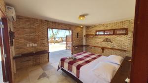 a bedroom with a bed and a brick wall at BEACH HOUSE - Loggia Suite 4 - com cozinha - na praia -BEACHFRONT in Barra Grande