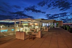 eine Terrasse mit Stühlen, Tischen und Sonnenschirmen in der Nacht in der Unterkunft Hilton Nashville Green Hills in Nashville